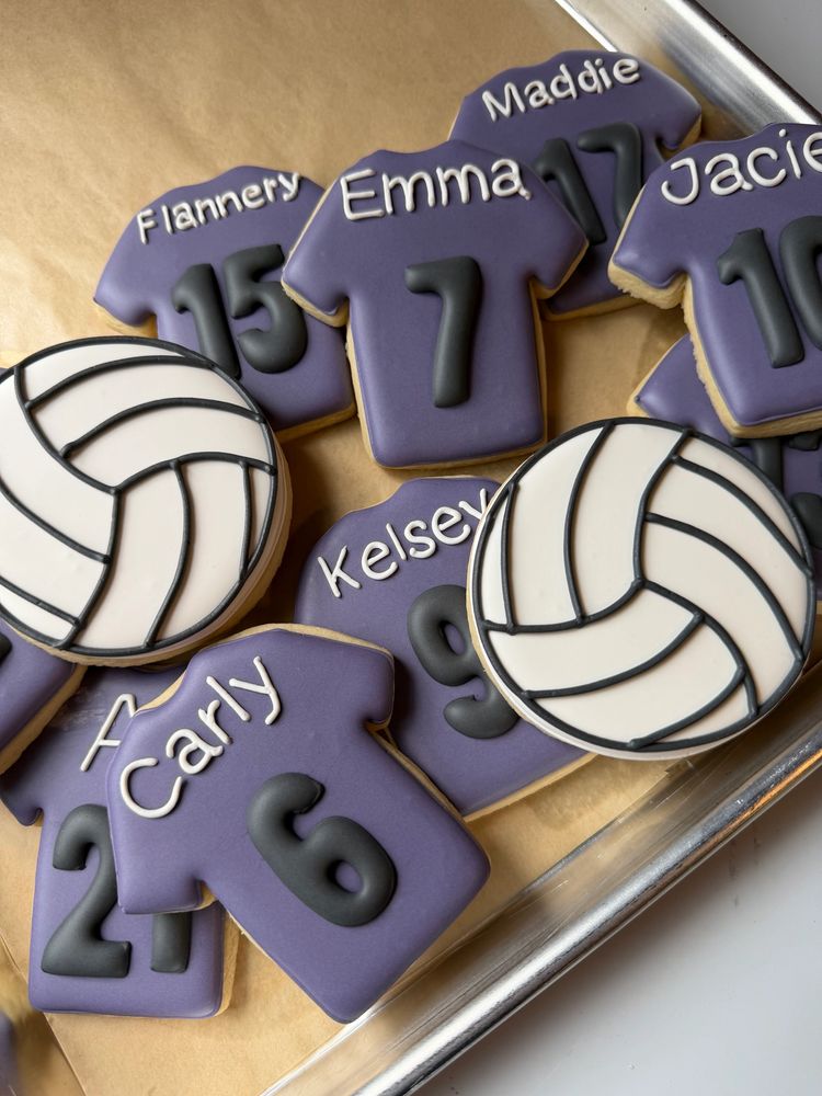 Purple jersey cookies with player names and numbers beside volleyballs