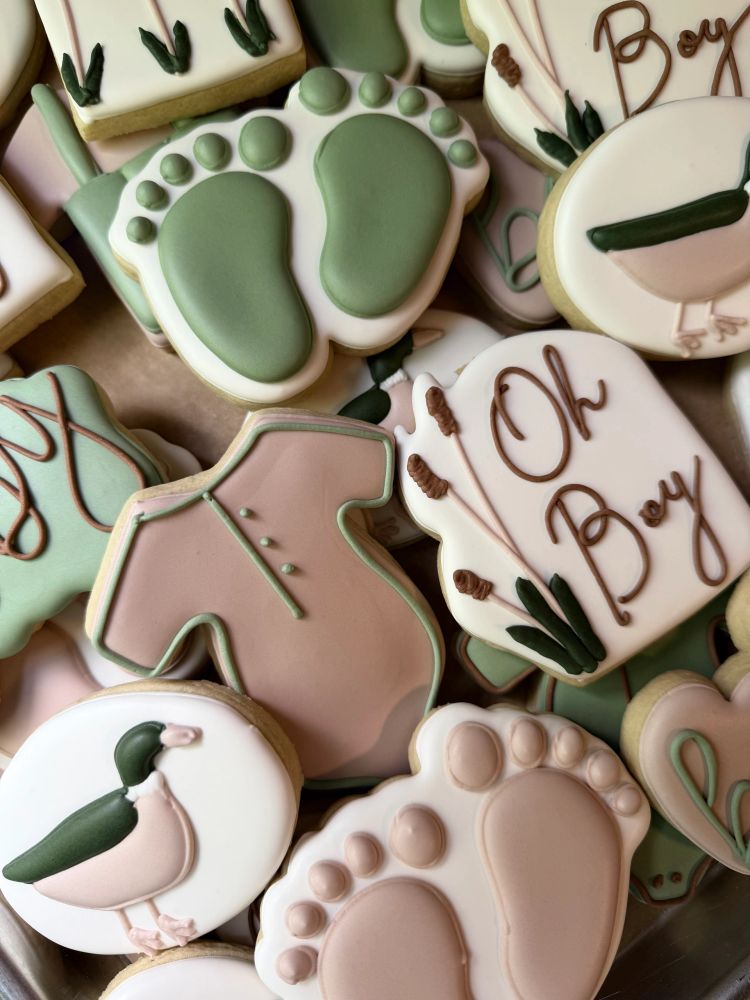 Sage and blush baby-boy cookies with ducks, footprints, and cattails