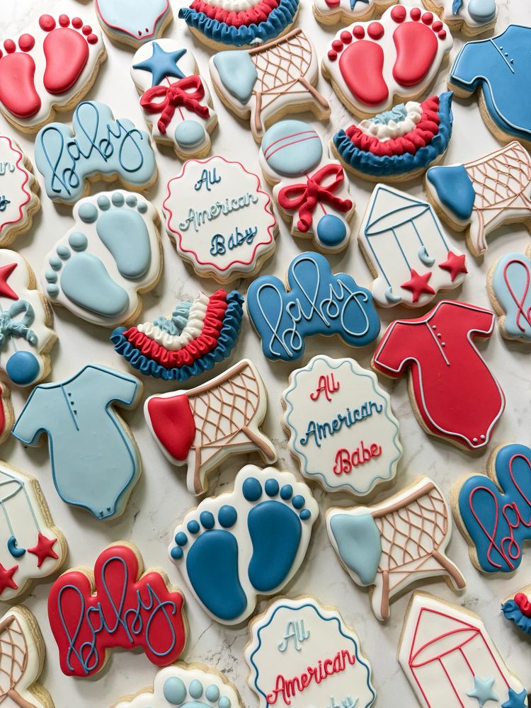 Red, white, and blue baby shower cookies with onesies, footprints, and bows