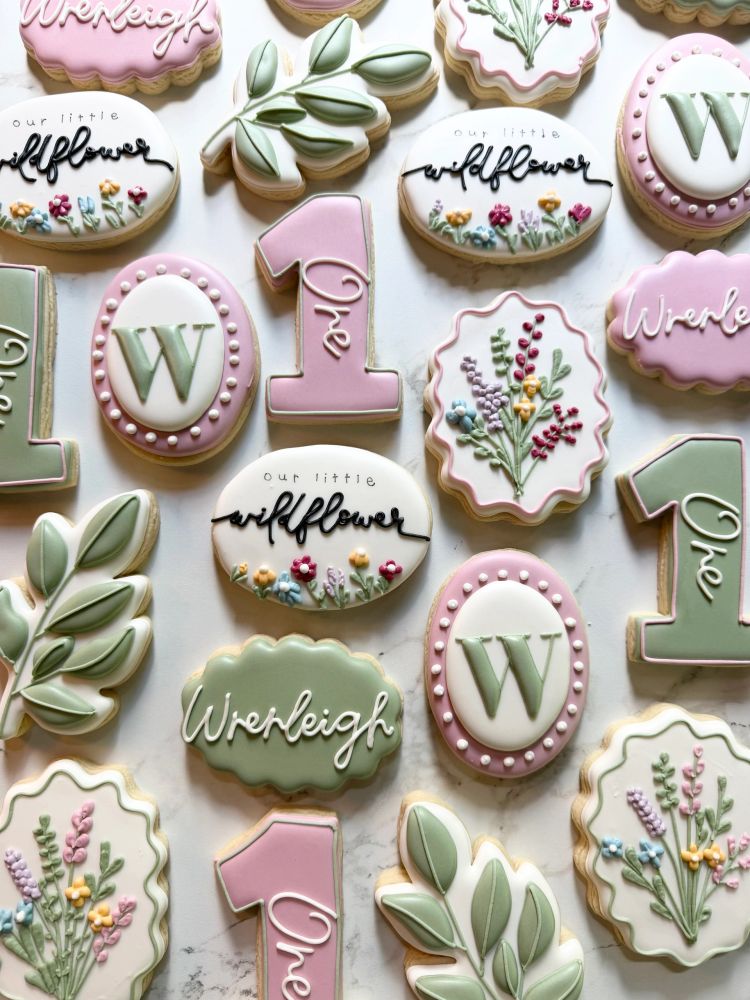 Sage and blush first-birthday cookies with leaves, wildflowers, and the number one