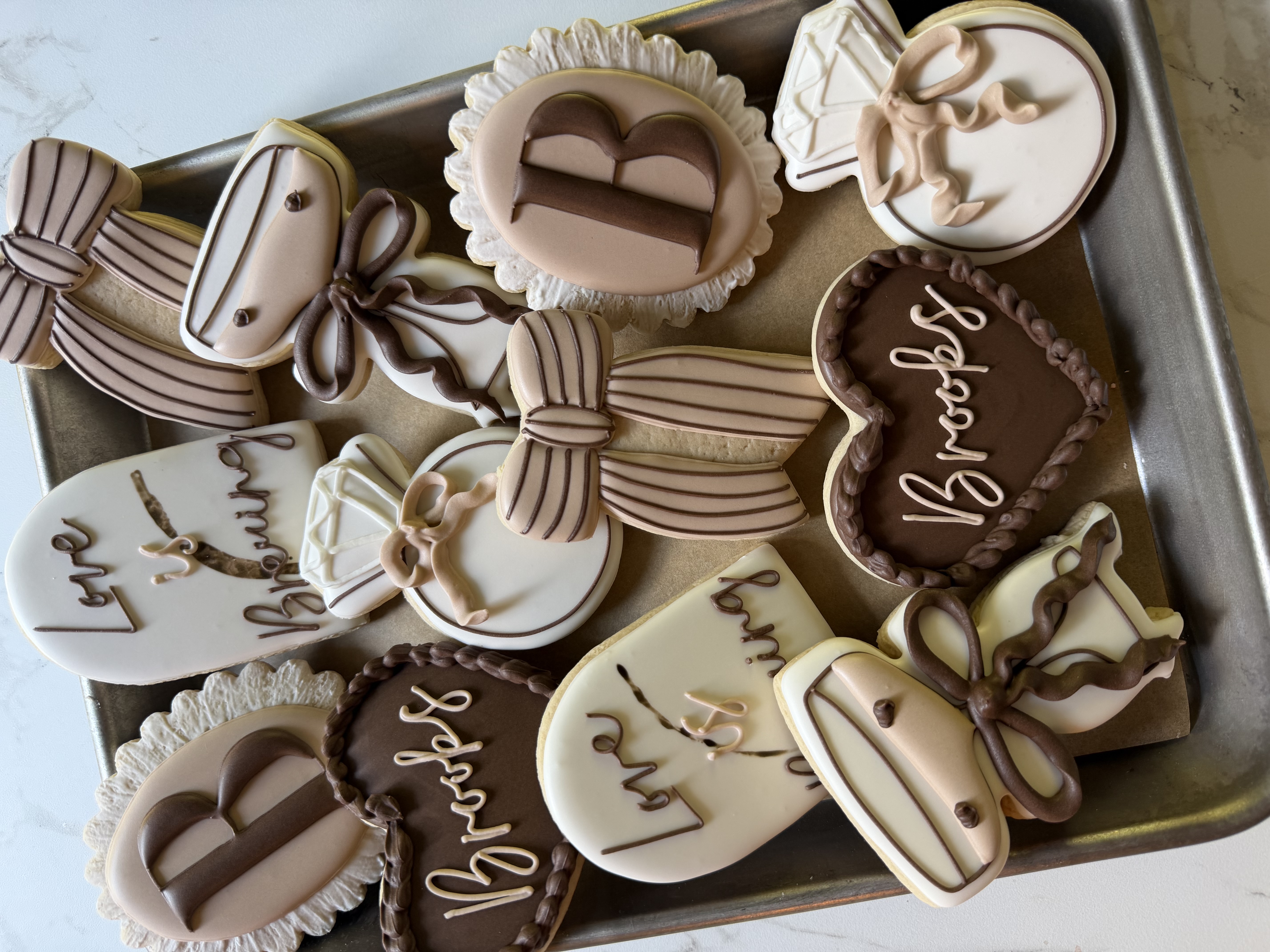 Bridal cookies in cream and cocoa with bows, rings, and Love is Brewing plaques